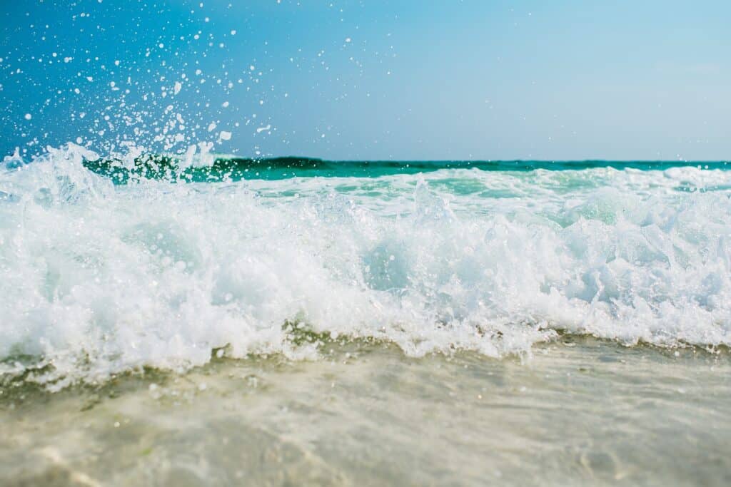 Dunn's River Falls Beach with crystal blue surf crashing against the white sandy beach.