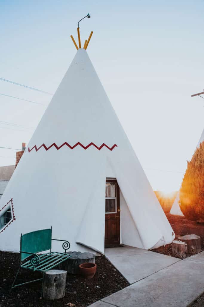 You're not going to find a much better family road trip idea than visiting this wig wam motel in AZ.  Here you can sleep in a traditional wig wam overnight, pictured here as a tall white wig wam with a brown door.