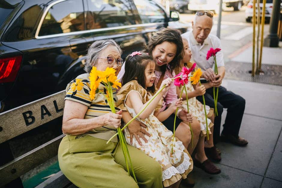 International Travel With Children - a family sitting outside on a bench together in Bali with flowers in their hands.